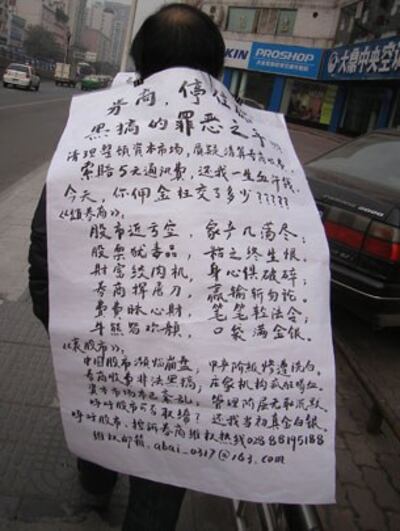 图片:四川成都的股民到证监局投诉当局对证券商管理不严的做法,他们并在身上挂起标语条幅,沿街控诉。(志愿者提供)