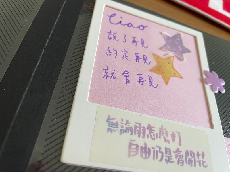 好友精心製作小相簿作為道別禮物,周萬聰珍而重之帶到英國,翻開小本子,裡面貼滿香港好友的快樂合照,也寫滿了祝福。其中一句,寫了一句歌詞——「說了再見 約定再見 定會再見。」(呂熙 攝)