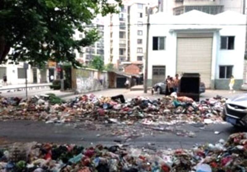 湖北省荊州市沙市區環衛工人，周二（6月25日）因與環衛公司談判破裂後全線罷工，工人不斷將垃圾傾倒在馬路上，以示抗議。(相片由現場人士提供) 