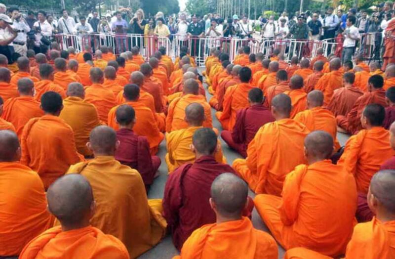 ព្រះសង្ឃ​គង់​ធ្វើ​សមាធិ​បួង​សួង​សុំ​សន្តិភាព​នៅ​ខាង​មុខ​រនាំង​របស់​សមត្ថកិច្ច ក្រោយ​ពី​សមត្ថកិច្ច​រារាំង​មិន​ឲ្យ​និមន្ត​ទៅ​ខាង​មុខ​ព្រះបរមរាជវាំង នៅ​ថ្ងៃ​ទី​១៩ កញ្ញា ឆ្នាំ​២០១៣។