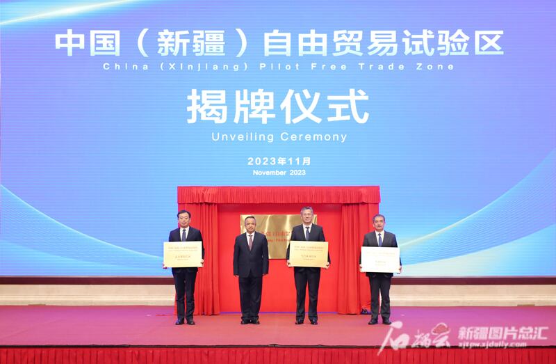 ئۇيغۇر ئاپتونوم رايوننىڭ رەئىسى ئەركىن تۇنىياز ئۈرۈمچى، قەشقەر، قورغاستىن ئىبارەت ئۈچ جايغا ئەركىن سودا سىناق رايونى لەۋھە تاختىسى بەرگەن كۆرۈنۈش، 2023-يىلى 1-نويابىر، ئۈرۈمچى