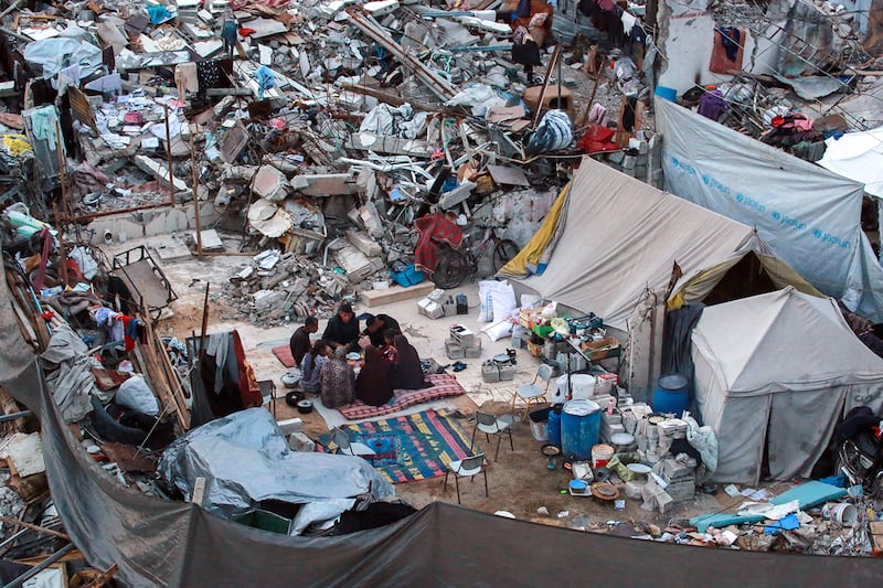 In this undated photo, Dr. Khaled Mohammed Abu Jari, 57, center left, head of the critical care department at the Beit Hanoun Hospital has his fast-breaking iftar meal with his family outside their tent in Beit Lahia in the northern Gaza Strip during the Muslim holy fasting month of Ramadan.