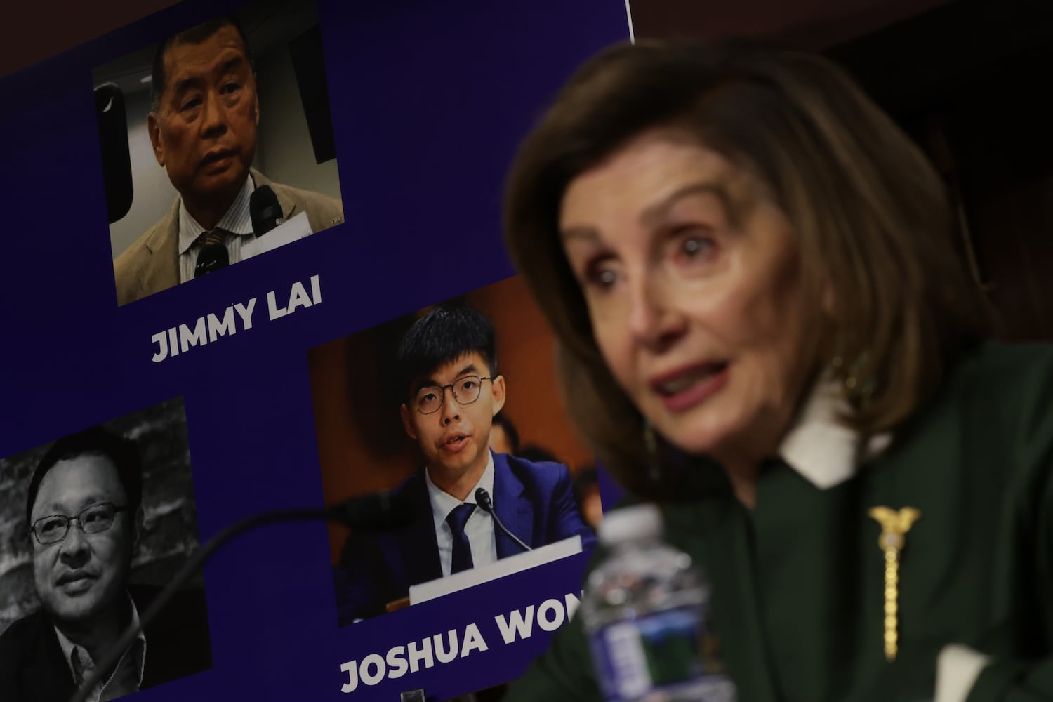 As photos of Hong Kong democracy activists (clockwise from top) Jimmy Lai, Joshua Wong and Benny Tai are on display in the background, U.S. Speaker of the House Rep. Nancy Pelosi testifies during a hearing before The Congressional-Executive Commission on China (CECC) at Dirksen Senate Office Building on Capitol Hill on February 3, 2022 in Washington. (Alex Wong/Getty Images)