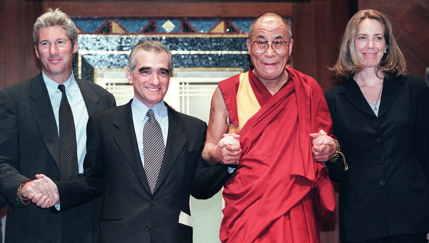 In this April 30, 1998, photo, from left to right: Richard Gere, director Martin Scorsese, the Dalai Lama and screenwriter Melissa Mathison hold hands at an awards ceremony honoring Scorsese and Mathison for their work on the film