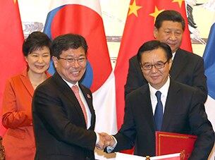 지난 10일 중국 베이징 인민대회당에서 박근혜 대통령과 시진핑 중국 국가주석이 지켜보는 가운데 윤상직 산업통상자원부 장관과 가오후청 중국 상무부장이 한중 자유무역협정(FTA)에 서명한 뒤 서명서를 교환하며 악수하고 있다.