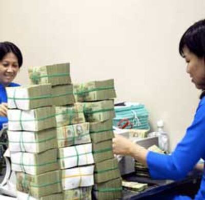 Các nhân viên ngân hàng đang kiểm đếm tiền đồng Việt Nam. Photo courtesy of vneconomy.