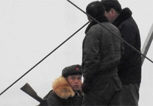 중국 단둥시 외곽 북·중 국경지대에서 북한 주민들과 국경수비대가 이야기를 하고 있다.