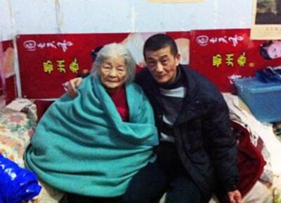 图片：鲍俊生出狱后，在家中与母亲合照。（家人提供）