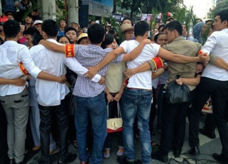 Công an mặc thường phục làm hàng rào ngăn chặn người dân đến tòa án Hà Nội trong ngày xử luật sư Lê Quốc Quân, 2/10/2013.
