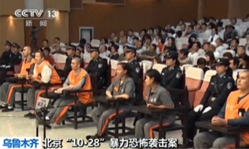 This CCTV screen grab June 16, 2014 shows prisoners (seated -- in orange and brown) at the Intermediate People's Court in Urumqi during the trial of those accused of staging the October, 2013 deadly attack at Beijing's Tiananmen Square. ((AFP PHOTO/CCTV) 