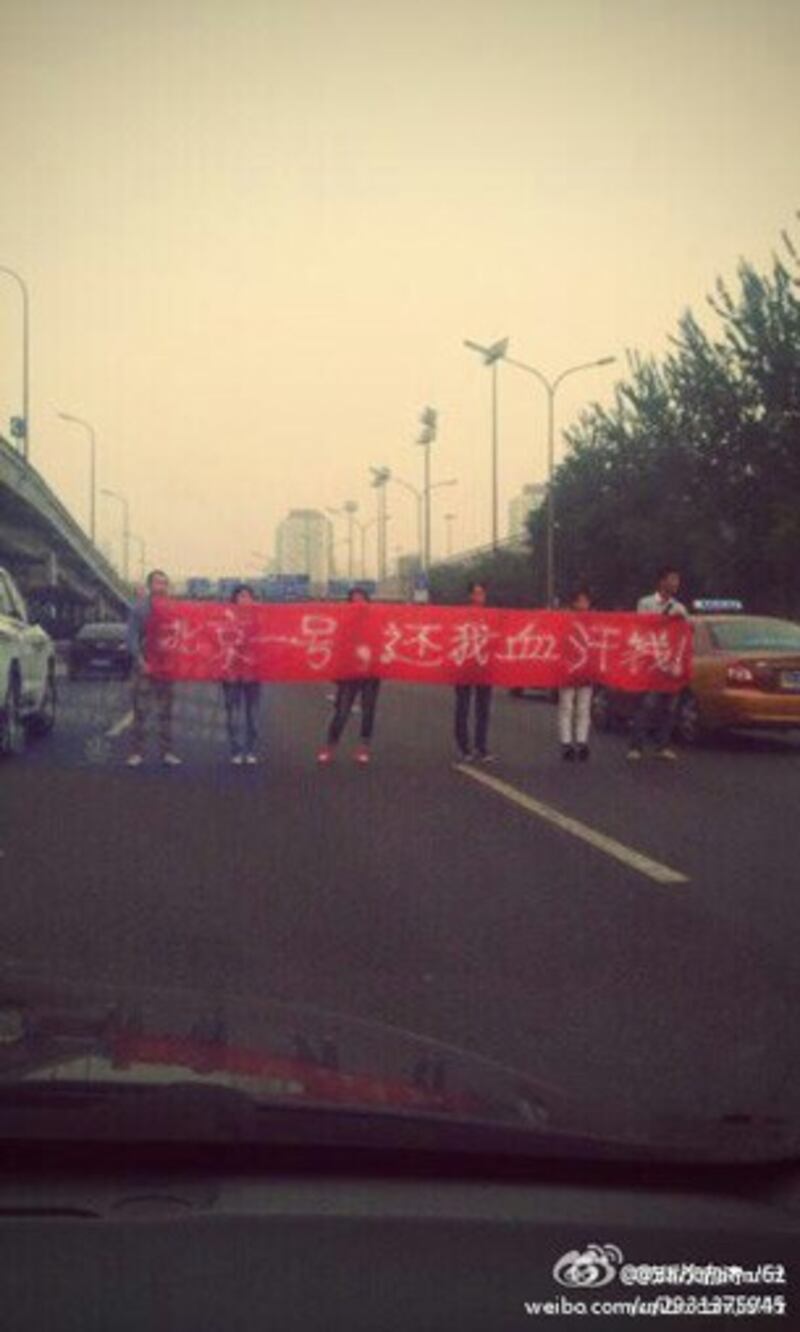 图片： 北京的多名工人拦路讨薪。 （新浪微博/记者乔龙）