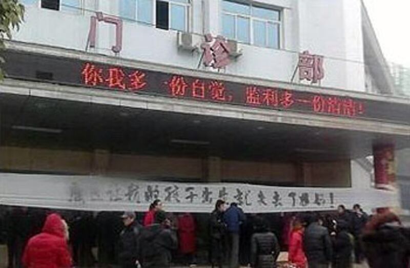 湖北省荊州市27歲孕婦到監利縣中醫院剖腹產子後突然腦出血，經搶救多日無效死亡，其家屬周六（1月19日）抬屍到醫院討說法，並掛上抗議橫額。（相片由死者家屬李先生提供）