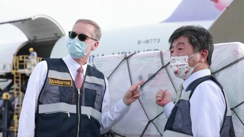 中国媒体讥讽台美关系是假友谊。图为今年6月美国捐赠250万剂疫苗运抵台湾。美国在台协会处长郦英杰（图左）和台湾卫福部长陈时中（图右）亲临接机。（视频截图）