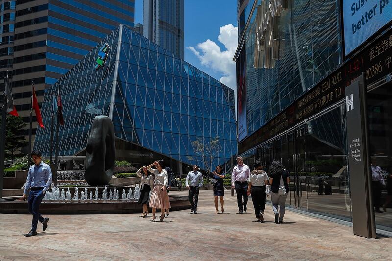 有舆论认为，特朗普反制中国的措施，反而令香港国际金融中心的地位更加重要。图为2019年8月5日，办公室工作人员走过一个电子板，显示5日香港金融区的股票价格。（美联社）