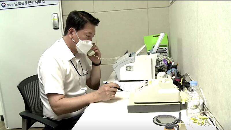 韩国统一部官员对重新接通的韩朝联络线电话。(路透社视频图)