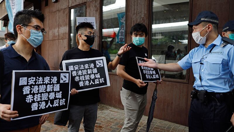 图为，在中联办前的抗议活动中，民主党成员举牌抗港版国安法。（美联社）