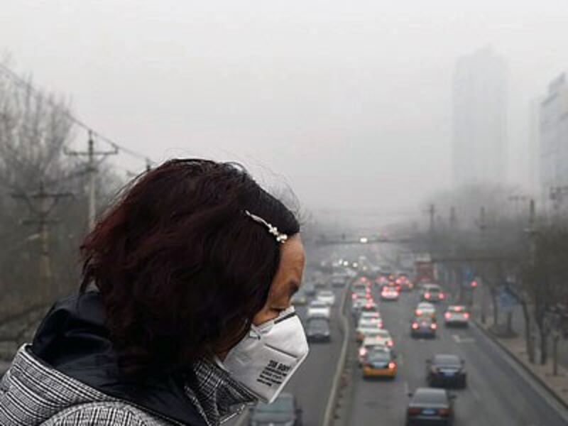A Chinese woman wears a face mask on a heavily polluted day in Beijing, Dec. 26, 2015.