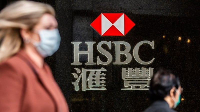 一名女士走过香港汇丰银行,台湾向香港金融人才招手。(法新社,资料照)