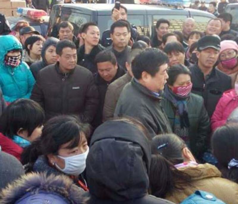 2015年1月23日,山東德棉股份有限公司四千多名工人再到東風中路上集體堵路抗議,要求政府協助討回工資。政府派出數百警察、警車包圍並驅散堵路工人。(工人攝)