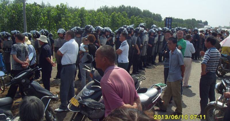 2013年6月10日，河南省許昌縣當局派出大批警察，築起人牆不許任何人接近煤礦公司。（村民提供）