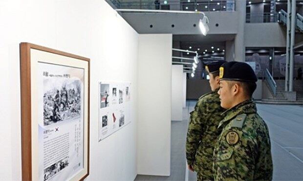 지난해 12월 서울 용산구 전쟁기념관에서 열린 '다시 보는 이달의 6·25전쟁영웅전' 전시에서 관람객이 6·25전쟁 영웅 12명의 공적내용과 포스터를 관람하고 있다.