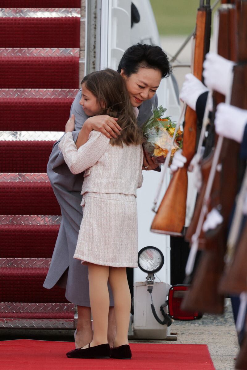 Chinese First Lady Peng Liyuan hugs a girl as she arrives with Chinese President Xi Jinping ahead of a state visit at Joint Base Andrews, Maryland, Sept. 23, 2026.