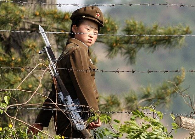 압록강 변의 한 수용소에서 북한 여군이 철조망 너머로 밖을 바라보고 있다.