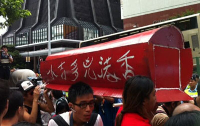 2012年7月1日，數名四五行動成員著寫有“香港兇多吉少”字樣的棺村，嘗試闖入升施禮會場，但遭警方阻止。（粵語部林靜攝）