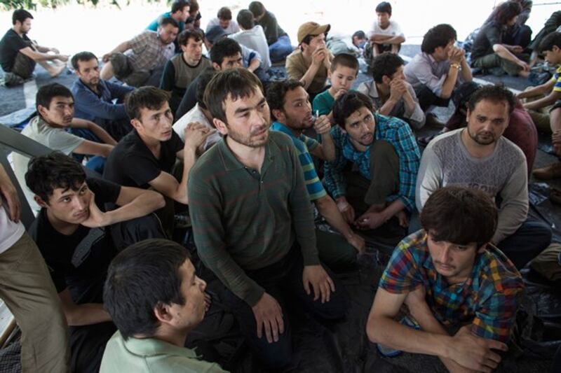 People believed to be Uyghurs sit inside a temporary shelter after they were detained near the Thailand-Malaysia border in Hat Yai, southern Thailand's Songkla province, March 14, 2014. Credit: Reuters