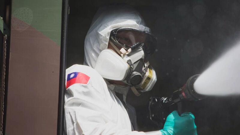 重型消毒车后座的国军,手持消毒器喷洒药水。(军闻社/蔡英文脸书)