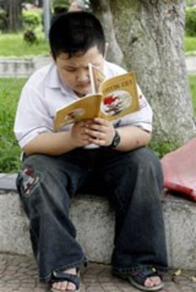 Một em học sinh đọc sách trong giờ ra chơi (minh họa)