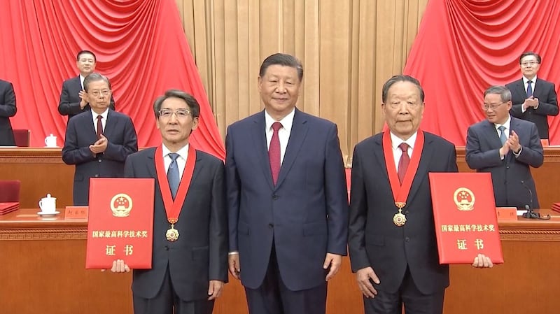 2024年6月24日,中共中央总书记习近平向获得2023年度国家最高科学技术奖的武汉大学李德仁院士(右)和清华大学薛其坤院士(左)颁奖。(视频截图:CCTV/AP)