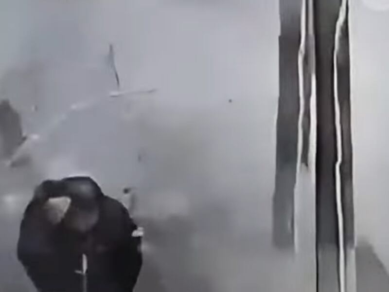 A man ducks during an explosion on the street in front of the "Dadong Food Mall in Shenyang, China, Jan. 28, 2025. Photo from video.