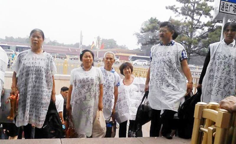 7月7日上午，中國總理李克強在人大會堂與德國總理默克爾會晤，湖北訪民穿申冤狀衣擬進入天安門被警方帶走。（照片來自中國天網）