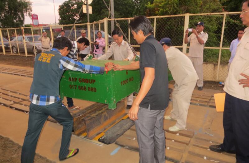 សកម្មភាព​ថ្លឹង​ដុំ​ដែក​សាកល្បង​ជញ្ជីង នា​អធិការ​ស្រុក​ត្បូងឃ្មុំ ខេត្ត​កំពង់ចាម កាល​ពី​ថ្ងៃ​ទី​២០ ខែ​ធ្នូ ឆ្នាំ​២០១៣។