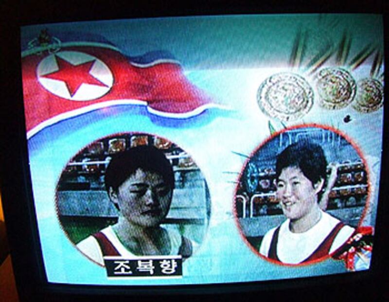 圖片4和10:記者進入站內,對平壤地鐵進行一番體驗。車上乘客稀落,他們都顯得非常安靜。記者還發現,偉大領袖的影響真可謂無所不在,包括每節地鐵車廂,在最高最當眼的位置,一定並排著金日成和金正日的畫像。另外,北韓的電視台也是全天候進行愛國教育,從早到晚都播放著體育節目,宣揚北韓是世界體育強國。