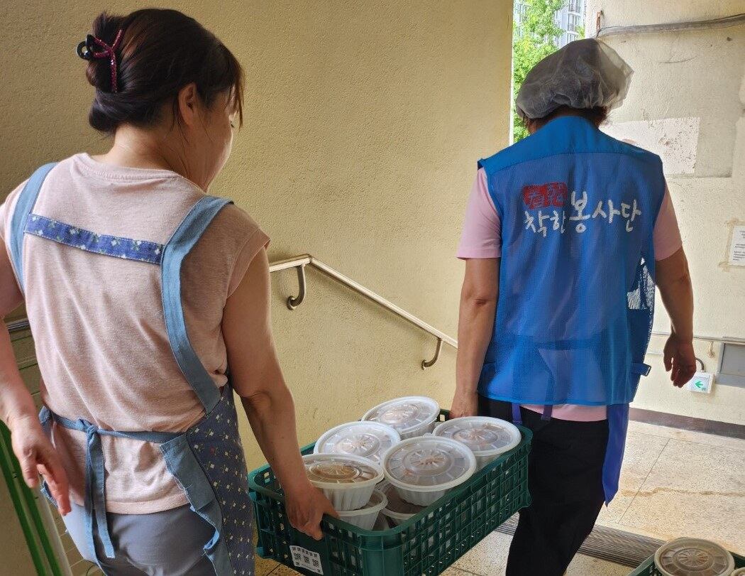 광명시에 거주하고 있는 탈북민들로 구성된 하나향우회 봉사단이 지역 주민들을 위해 준비한 삼계탕을 배식장소로 옮기고 있다.
