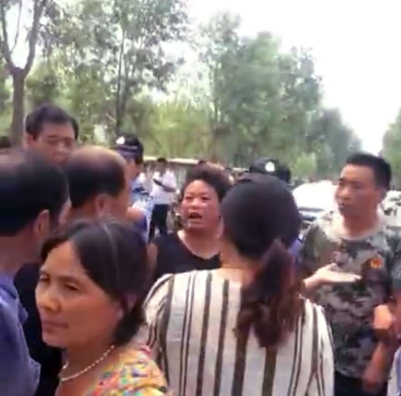 一穿迷彩T恤衫的男子带队强拆养殖场。(视频截图)