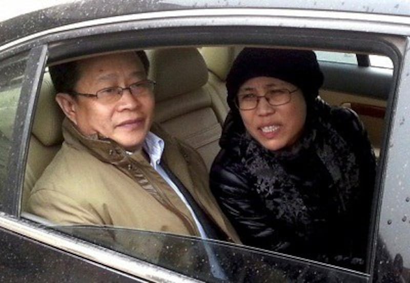 Liu Xia (r) and rights lawyer Mo Shaoping (l) arrive at court for her brother's trial in Beijing, April 23, 2013. Photo credit: AFP.