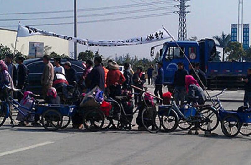 廣東江門睦洲鎮南安村村民拉起橫幅,同時堵塞廠房外的馬路,抗議政府私賣土地。(照片由南安村村民提供)