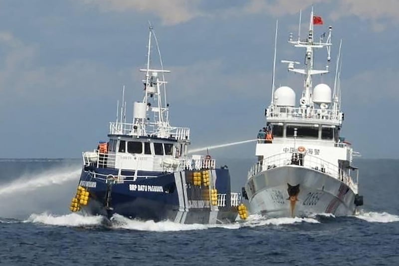An Oct. 12, 2025, photo distributed by the Philippine Coast Guard shows a China coast guard ship, right, deploying a water cannon at a Philippine Bureau of Fisheries vessel near Thitu island in disputed waters of the South China Sea.