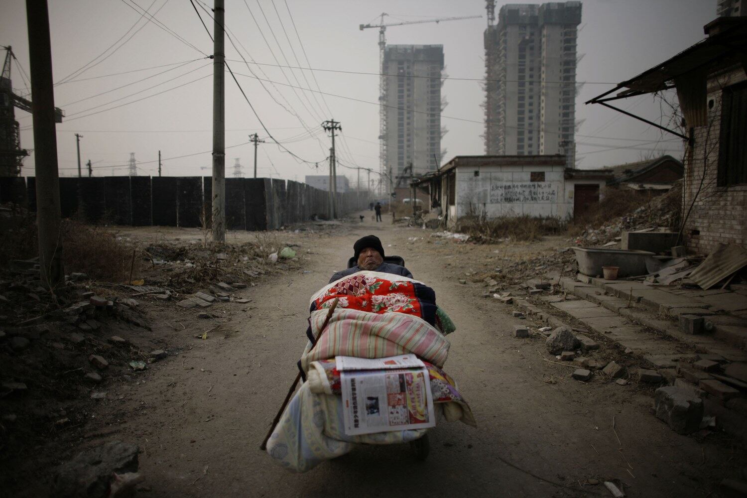 지난 2007년 한 남자가 베이징의 철거된 집 옆 휠체어에 앉아 있습니다.