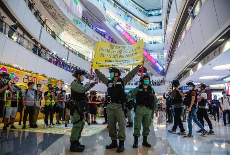 香港警察在一商场内举黄旗警告。(法新社)
