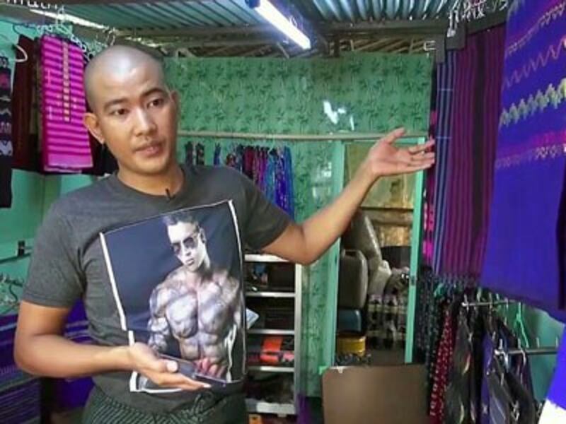 Aung Ko Htway shows some of the clothing for sale in the shop he runs with his sister in Kalaware village, Thanlyin township, in the suuburbs of Yangon, August 2017.