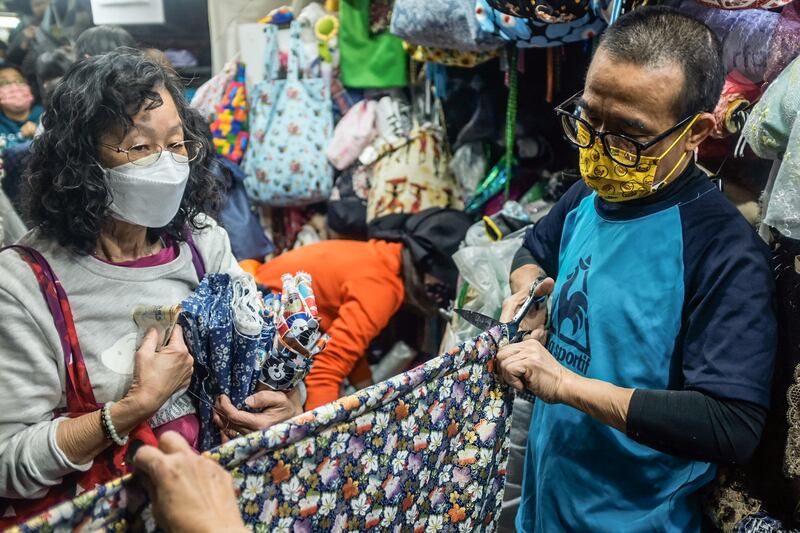 「信昌疋頭」第二代負責人馮先生（右）稱，感嘆在「棚仔」與街坊、檔友捱過一次次的風浪。（李若如攝）