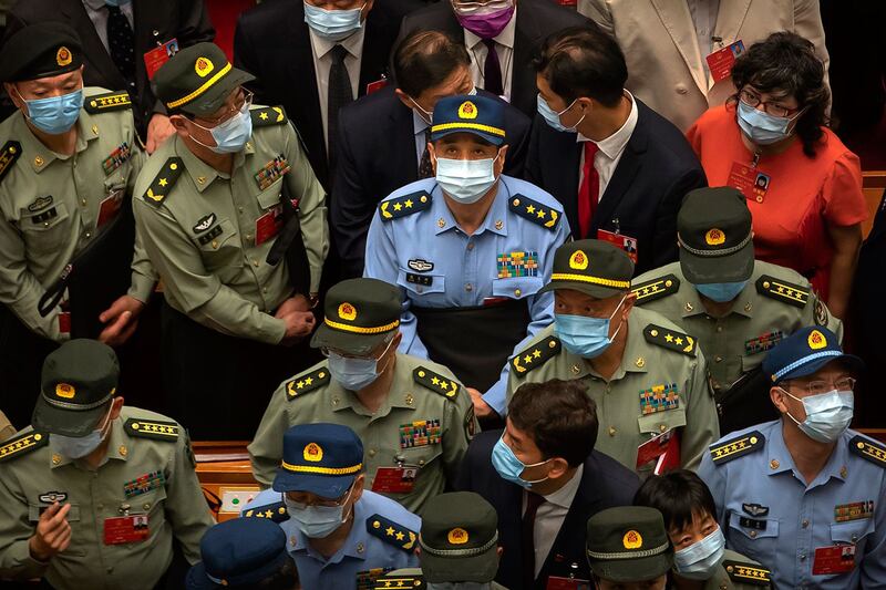 全国人大会议周四（28日）高票通过港版国安法，多个中央部门迫不及待地想要干预香港事务，公安部更发声明，指会全力指导支持香港警察止暴制乱、恢复秩序。图为人大会闭幕幕后，军方代表们等待离开。（美联社）