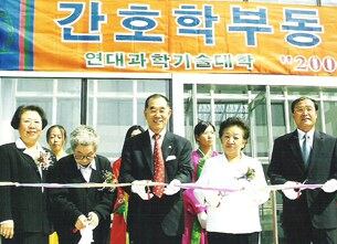 이송희 회장(오른쪽에서 두번째)이 연변과학기숙대학 간호학동 개관 테이프를 끊고 있다.