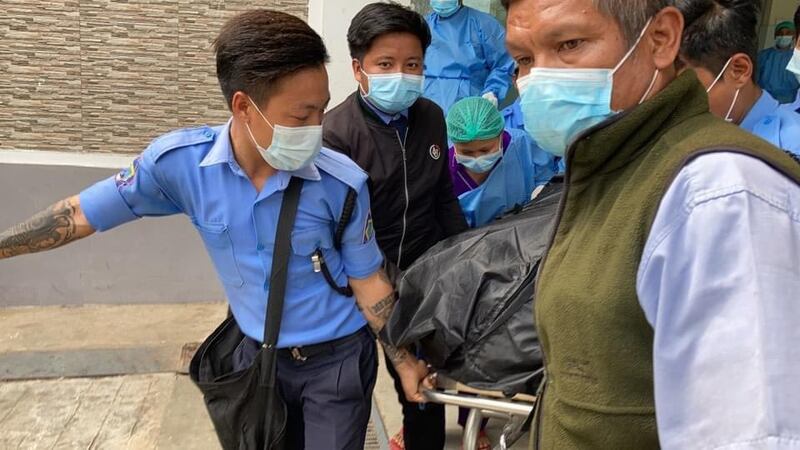 內比都有醫院職員把一個包裹妙兌兌凱遺體的黑色膠袋抬上貨車。(網絡圖片)
