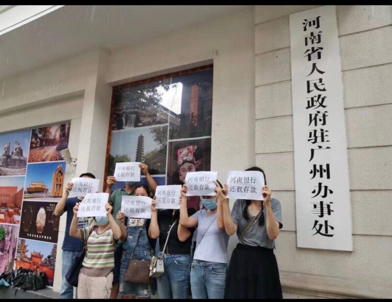 本月8日，有河南銀行苦主到河南省人民政府駐廣州辦事處門前舉牌抗議。（網絡截圖）