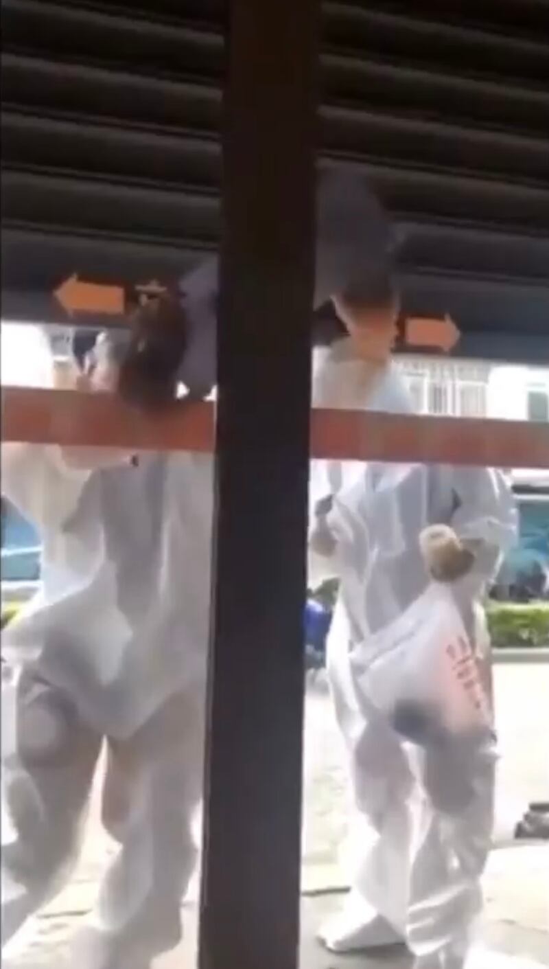 一住戶被隔離,防疫人員貼封條封門。(影片截圖)